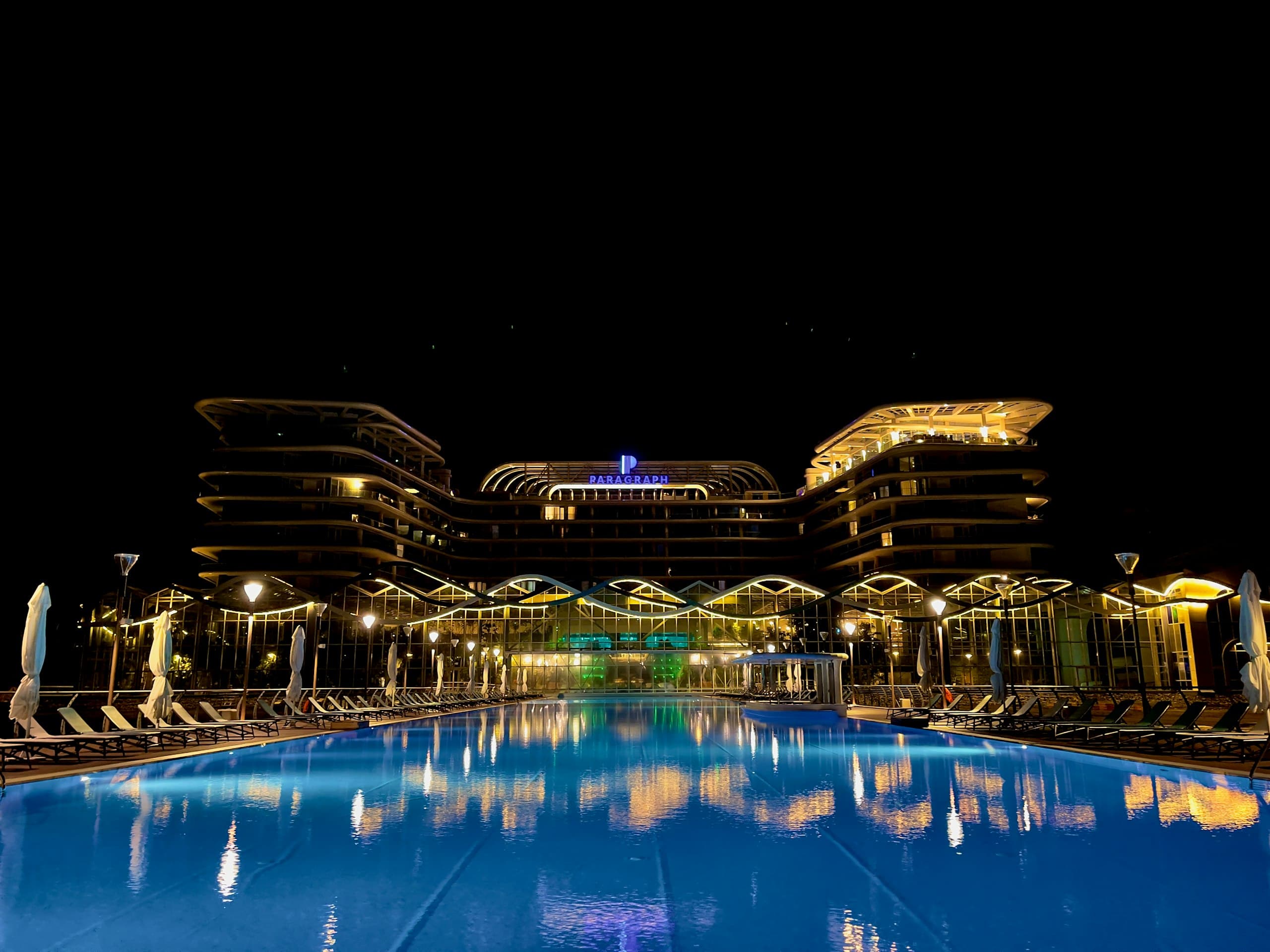 Resort with an illuminated infinity pool at night