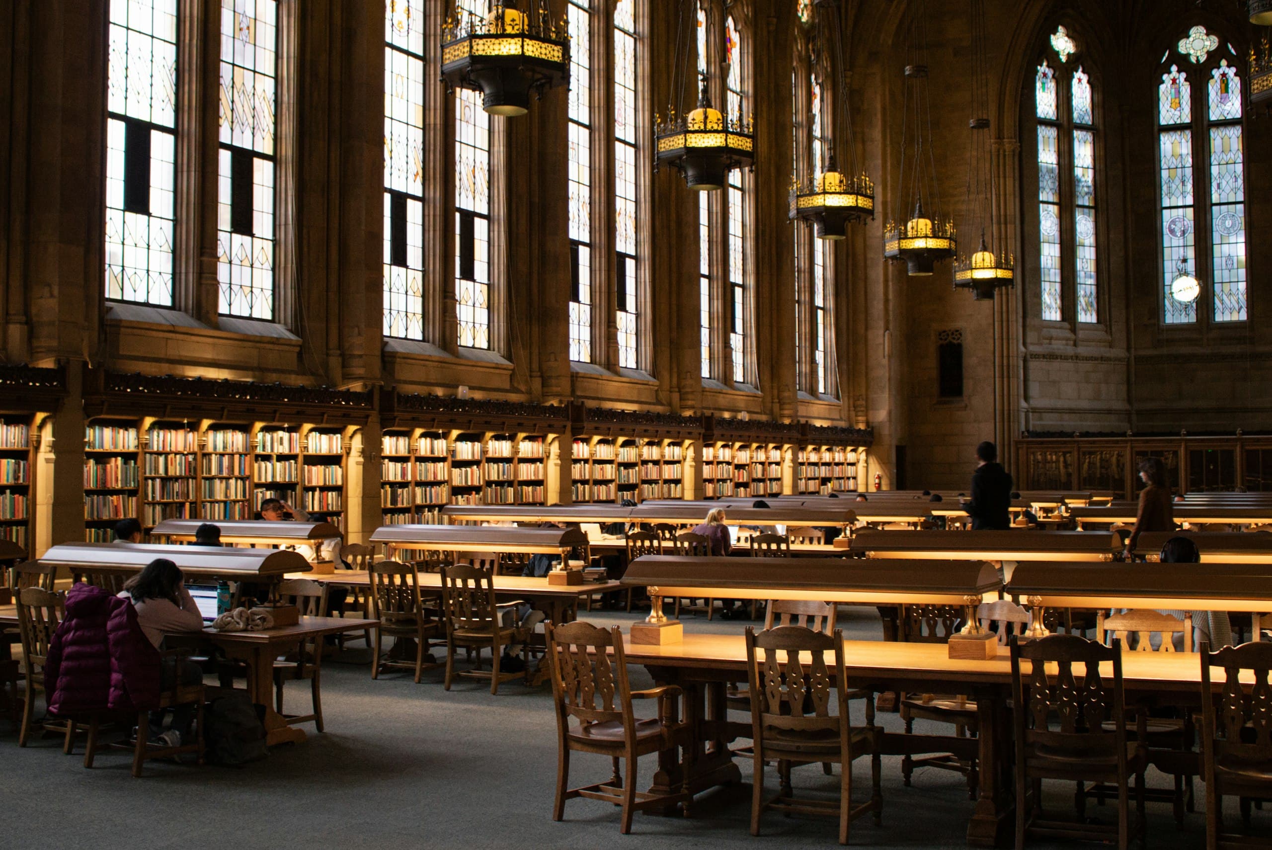 Students studying in a grand library hall